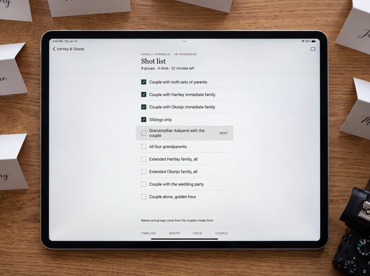 A tablet lying flat on a desk, showing the family shot list.