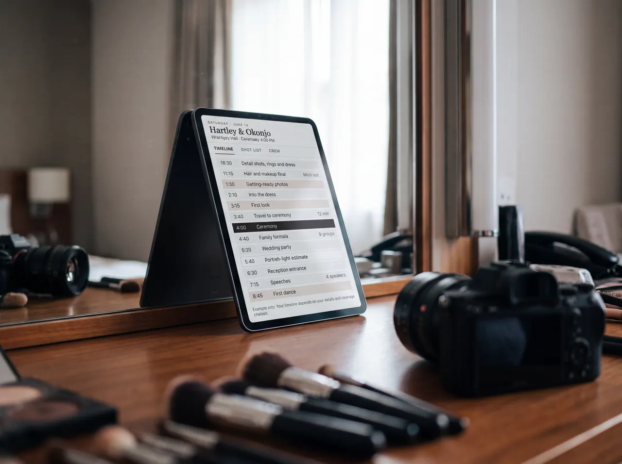A tablet on a getting-ready vanity beside brushes and a camera, showing the coverage timeline.